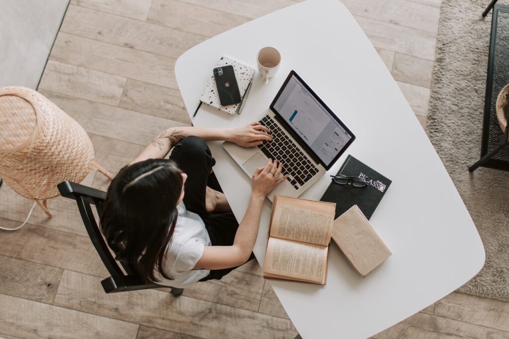 Above view image of woman on a computer with books