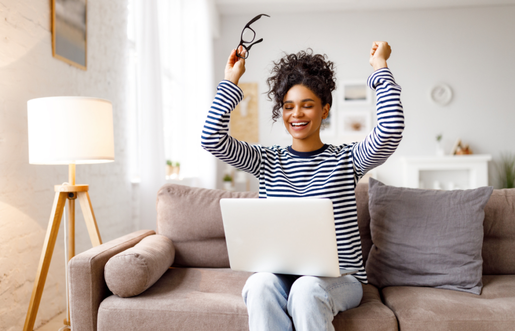 JLNICH blog beats article, NaNoWriMo is Done: A 50,000 Word Count or Rebel Goal Reached. woman with hands raised in celebration, laptop on lap