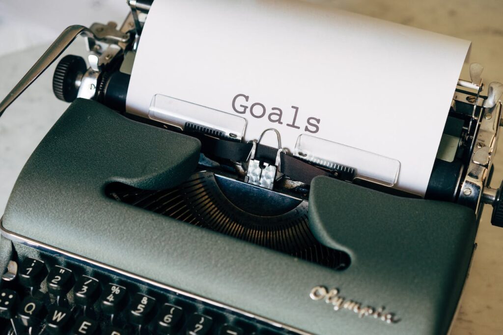 JL NICH blog beats article, 2024 Beyond SFF Writing Goals: How to Ensure Success. Image of a typewriter with the word Goals on it.