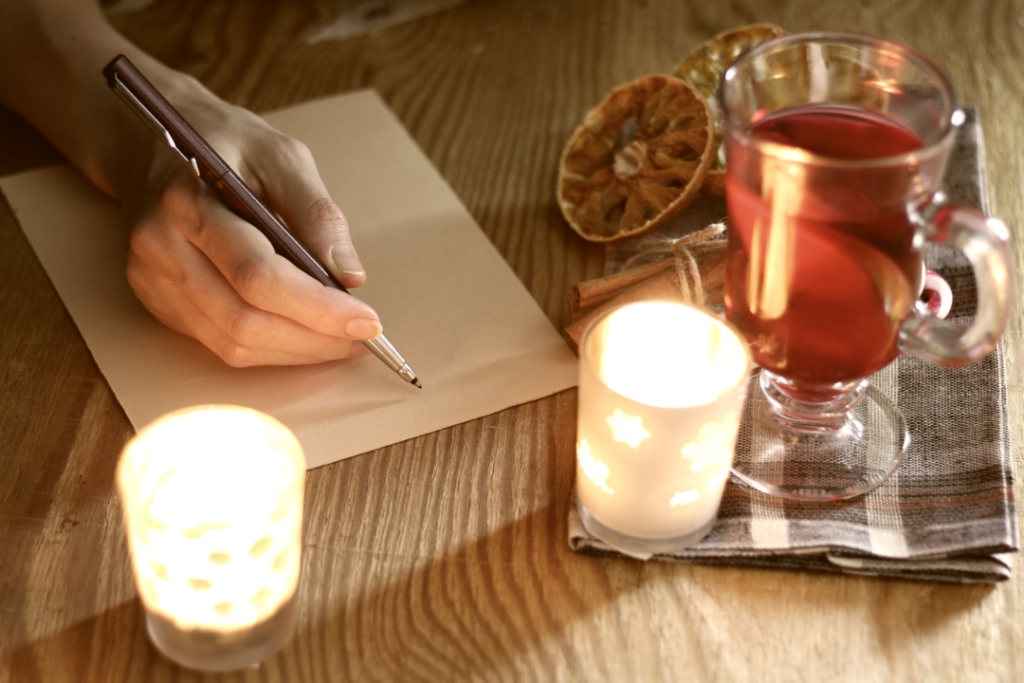 JL NICH blog beats article, Yuletide Imagination: Crafting Holiday Short Stories. Cover image of someone writing.